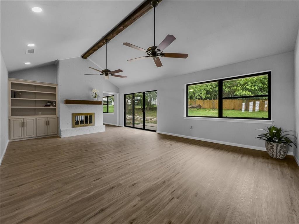 136 Southwest Rand Drive Burleson, TX 76028 - Photo 7 of 25 an empty room with wooden floor fireplace and windows