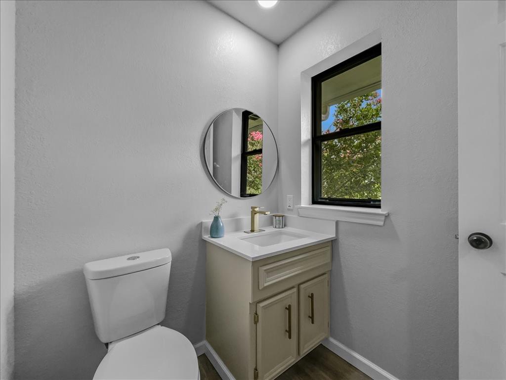 136 Southwest Rand Drive Burleson, TX 76028 - Photo 9 of 25 a bathroom with a toilet sink vanity and mirror
