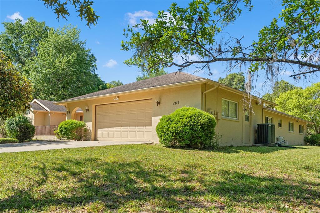1379 Matthew Avenue Spring Hill, FL 34609 - Photo 1 of 55 a front view of a house with a yard and garage