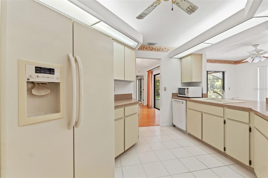 1379 Matthew Avenue Spring Hill, FL 34609 - Photo 14 of 55 a kitchen with a refrigerator and white cabinets