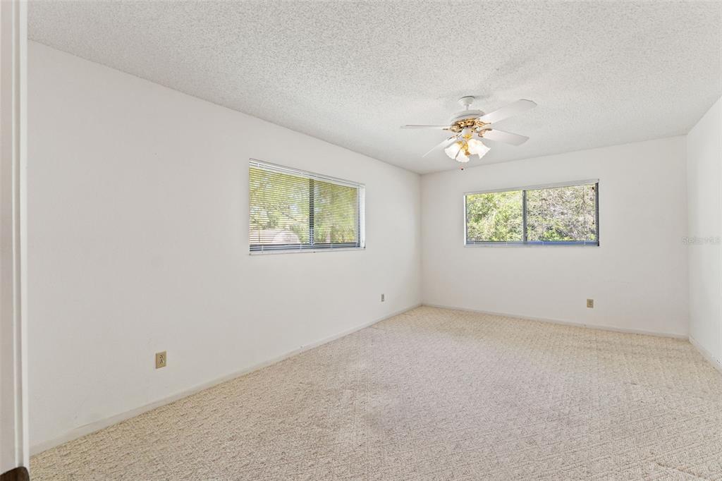 1379 Matthew Avenue Spring Hill, FL 34609 - Photo 35 of 55 an empty room with windows and chandelier fan