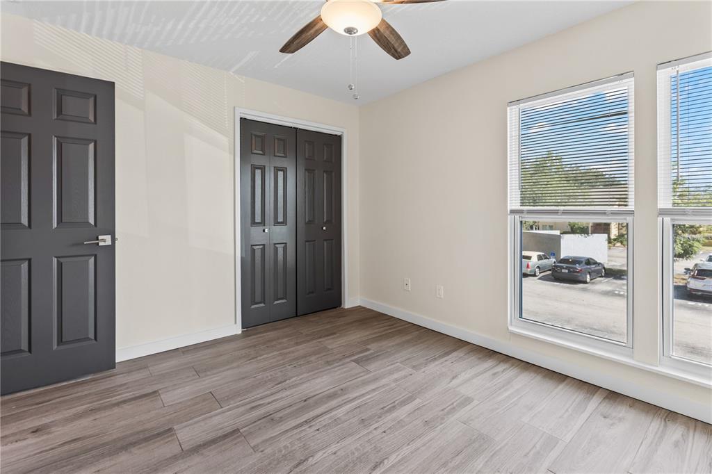 3405 Clark Road, Unit 205 Sarasota, FL 34231 - Photo 14 of 28 an empty room with wooden floor fan and windows