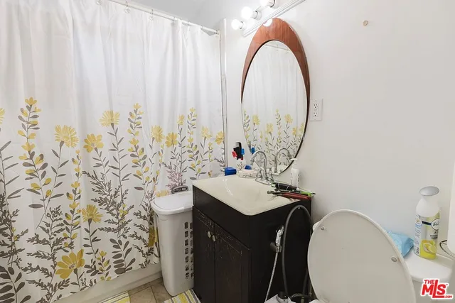 a view of a white building among the street with parked cars