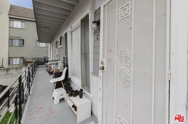 a kitchen with stainless steel appliances a refrigerator a sink a stove and white cabinets with wooden floor