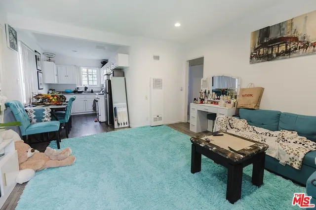 a kitchen with stainless steel appliances granite countertop a stove a sink dishwasher and white cabinets with wooden floor