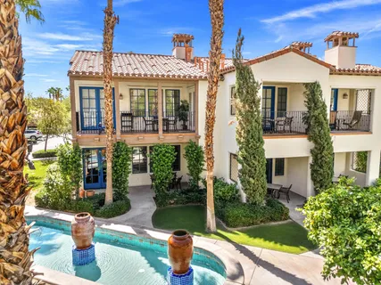 front view of a house with a yard and potted plants