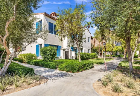 a view of a patio with couches and table and chairs plants and large trees