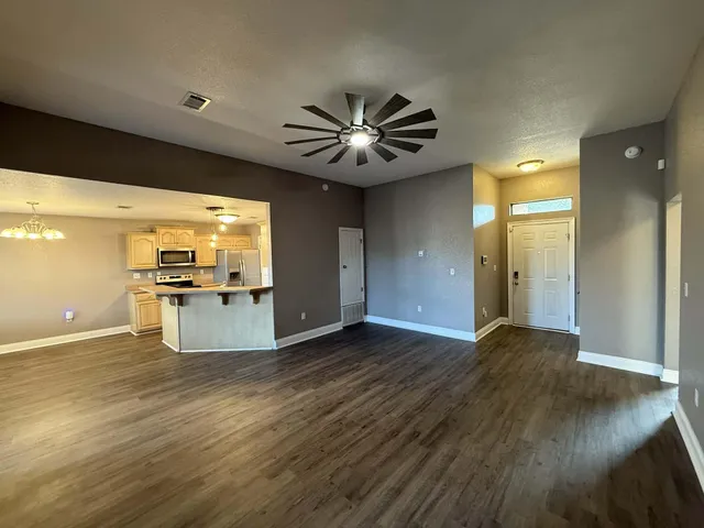 a view of a kitchen with wooden floor and a ceiling fan