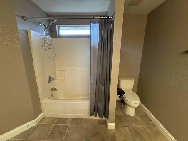 a bathroom with a toilet and a shower