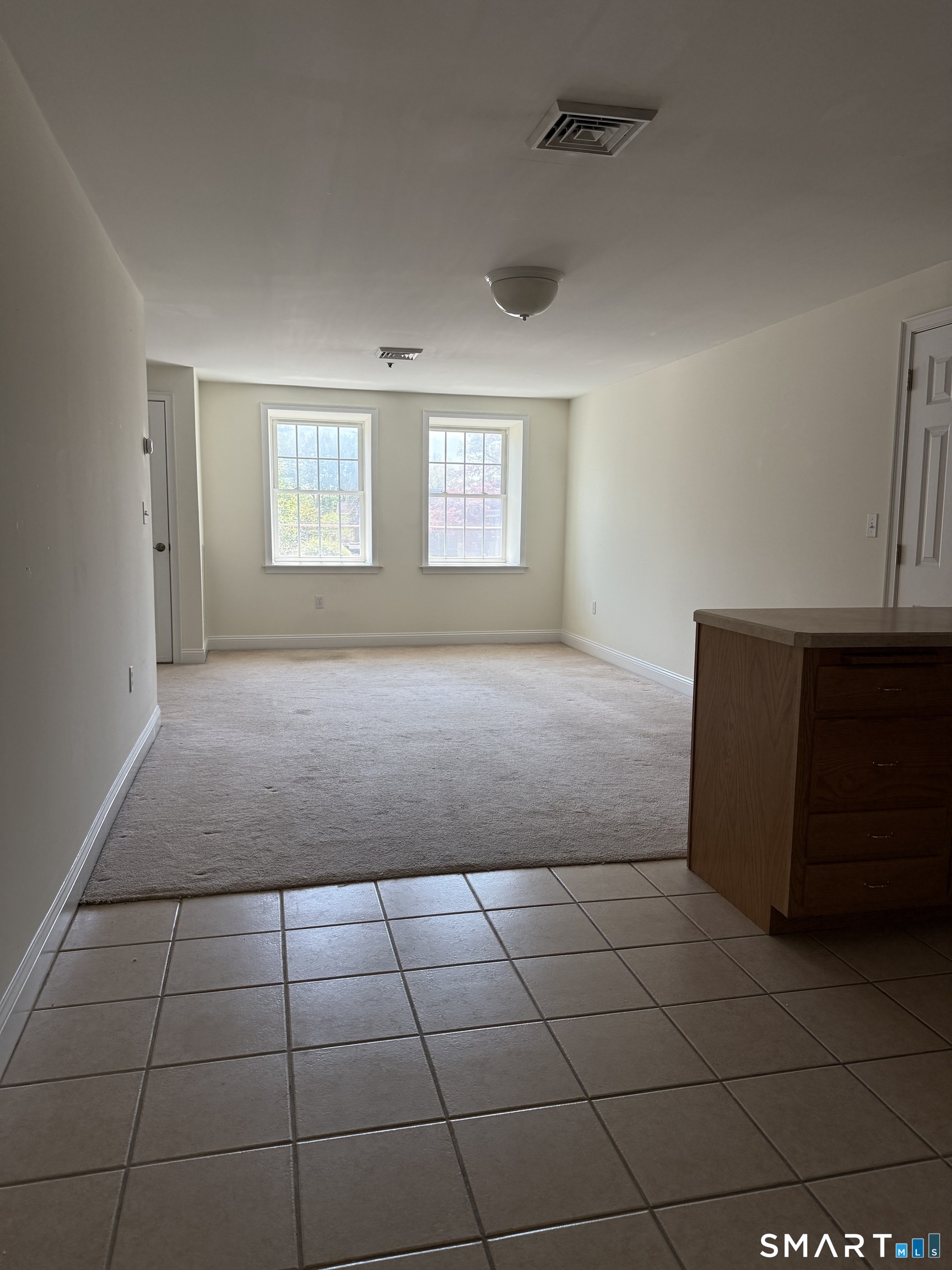 380 Main Street, Unit 16 Wallingford, CT 06492 - Photo 4 of 12 a view of a livingroom with an empty space and a window