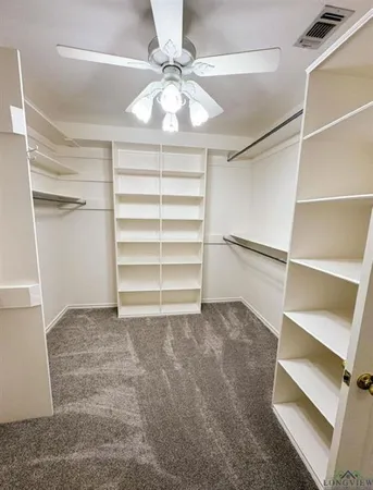 a view of an empty room with a ceiling fan
