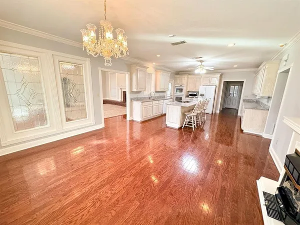 a view of a dining room with furniture a chandelier and wooden floor