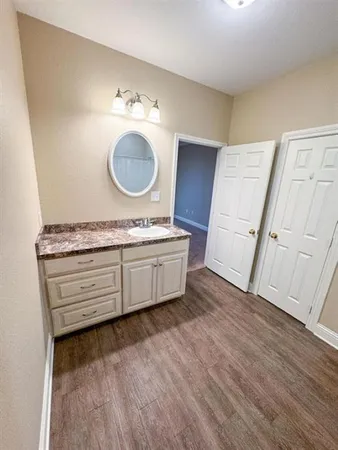a spacious bathroom with a granite countertop sink and a mirror