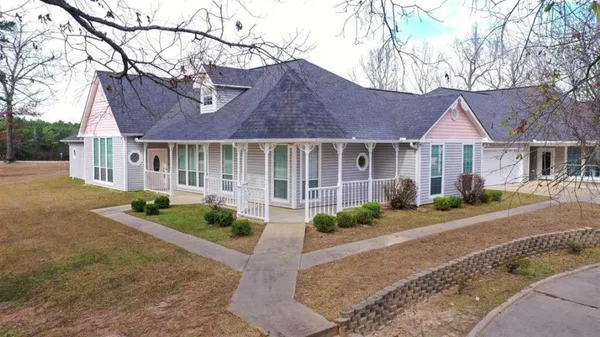 a front view of a house with a yard and outdoor seating
