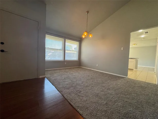 an empty room with a chandelier fan and closet