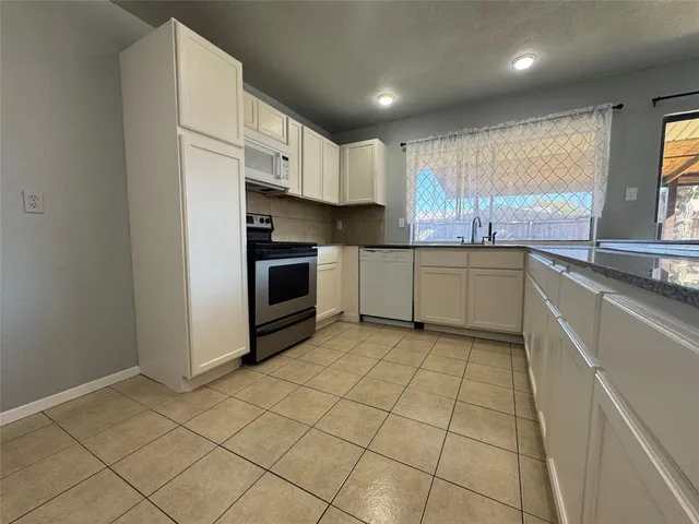 an empty room with a fireplace and large window