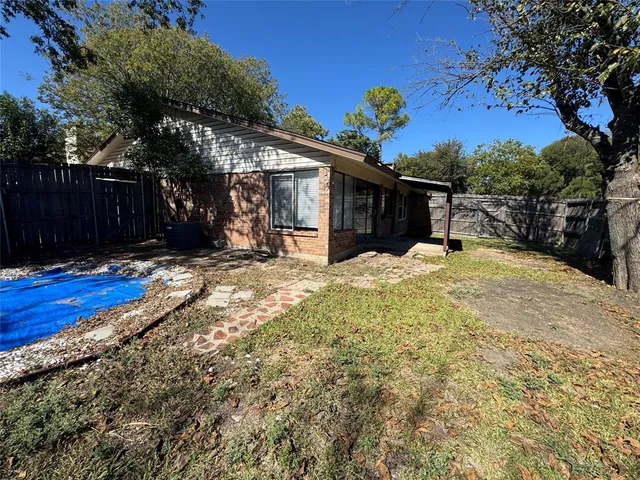 an empty room with wooden floor fireplace and windows