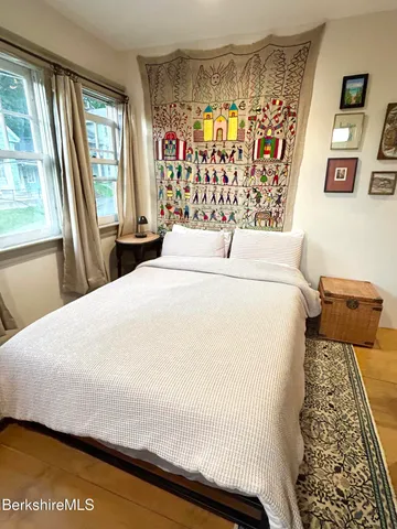 a bed sitting in a bedroom next to a window