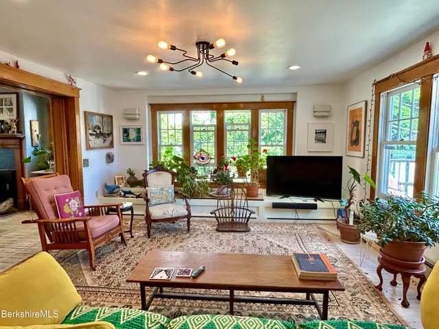 a living room with furniture a flat screen tv and a large window