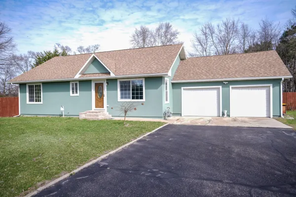 a front view of a house with a garden and yard