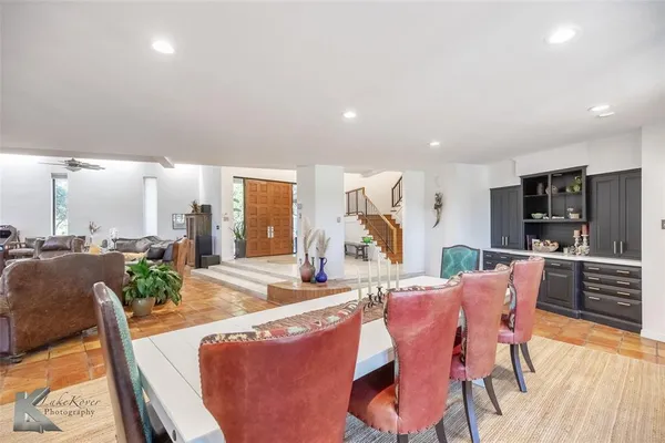 a living room with furniture a large window and wooden floor