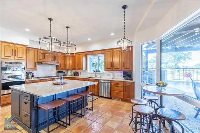 a kitchen with a stove a sink a counter top space and dining table