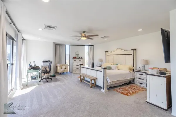 a bedroom with a bed a large window and furniture