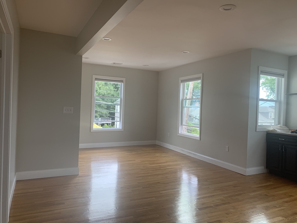 76 Eleanor Street, Unit 3 Chelsea, MA 02150 - Photo 2 of 9 a view of an empty room with wooden floor and a window