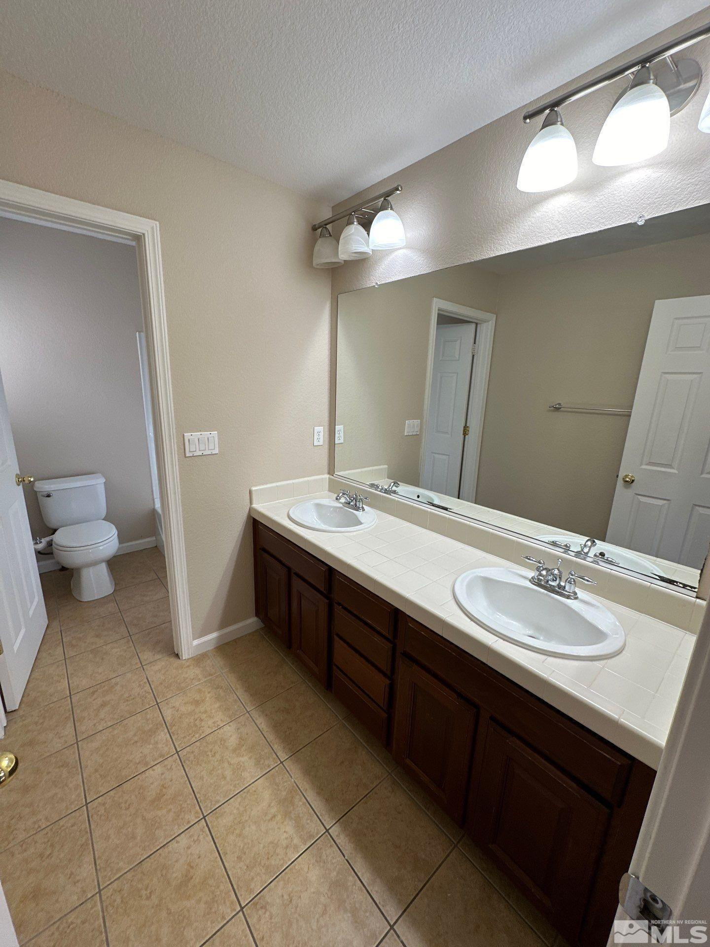3994 Dominus Drive Sparks, NV 89436 - Photo 12 of 18 a spacious bathroom with a double vanity sink and a mirror