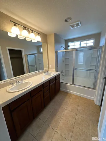 a bathroom with a double vanity sink mirror and bathtub
