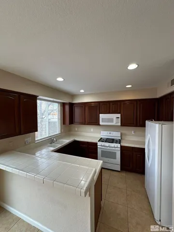 a kitchen with a refrigerator and a stove top oven