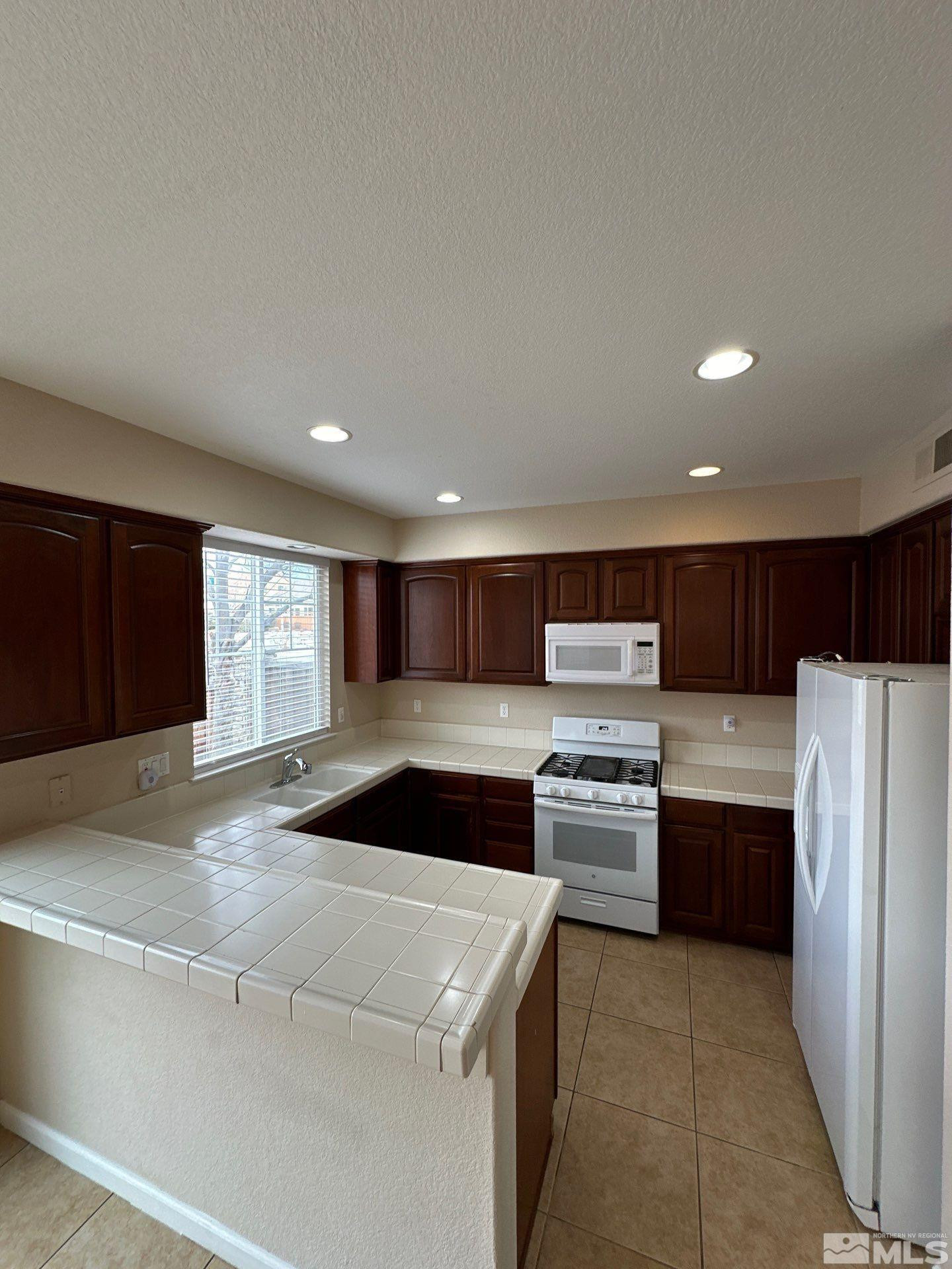 3994 Dominus Drive Sparks, NV 89436 - Photo 5 of 18 a kitchen with a refrigerator and a stove top oven