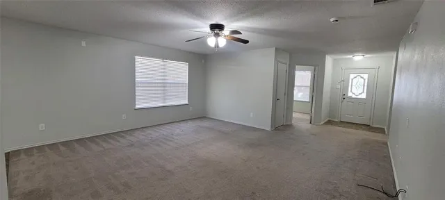a view of a big room with windows and chandelier fan