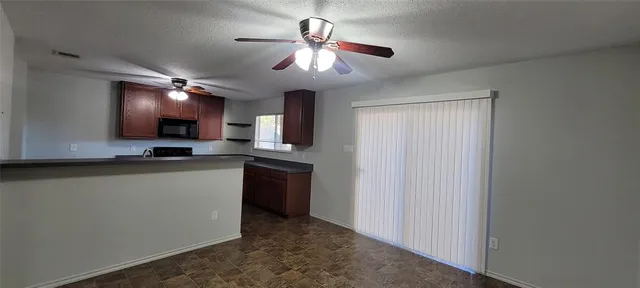 an empty room with fan and windows