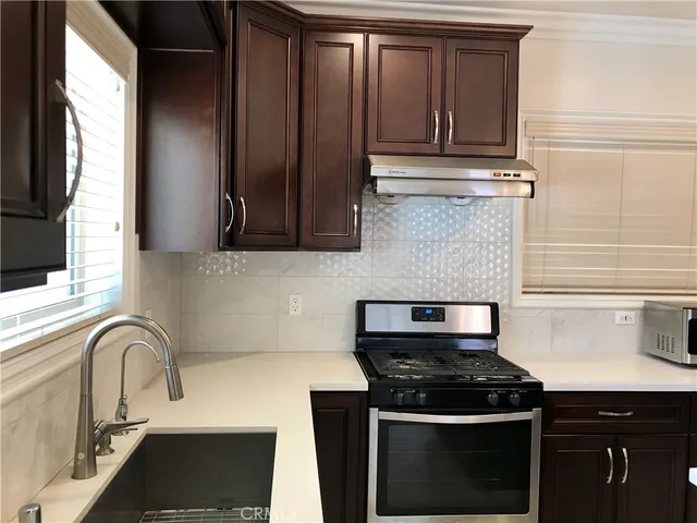 a kitchen with granite countertop a stove sink and cabinets
