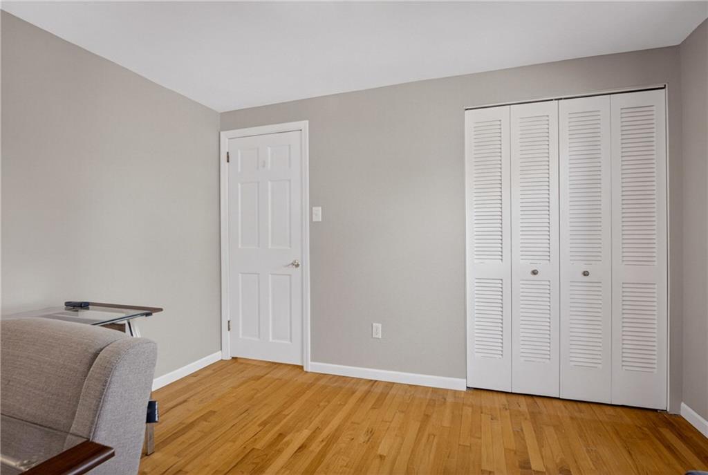1243 Sun Ridge Drive Pittsburgh, PA 15241 - Photo 28 of 43 Bedroom 4. Enjoy the versatility of this sun-drenched space, highlighted by warm wood flooring and clean lines. Featuring a spacious closet with classic louvered doors, this room easily adapts to your needs as a quiet workspace or traditional bedroom.