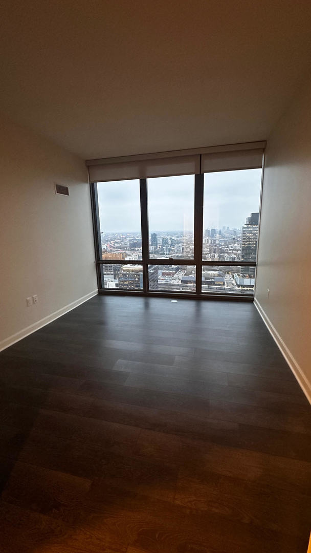 164 North Peoria Street, Unit 3002 Chicago, IL 60607 - Photo 11 of 20 a view of an empty room with wooden floor and a floor to ceiling window