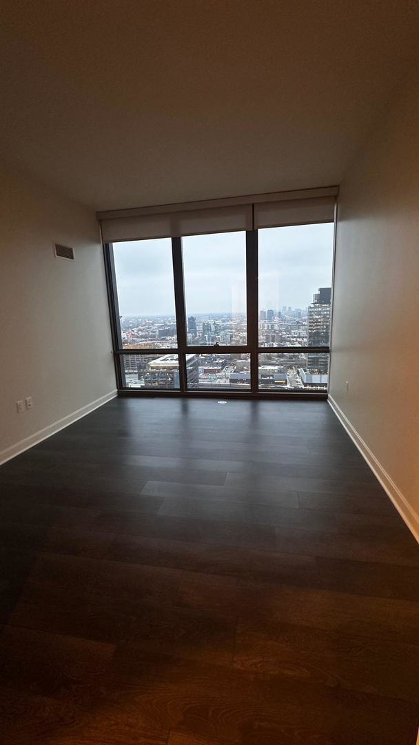 164 North Peoria Street, Unit 3002 Chicago, IL 60607 - Photo 10 of 20 a view of an empty room with wooden floor and a floor to ceiling window