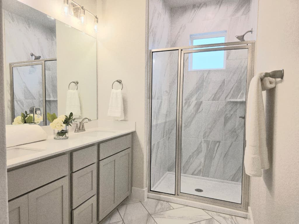 6416 Cowman Way Austin, TX 78747 - Photo 14 of 30 a bathroom with a shower sink and mirror