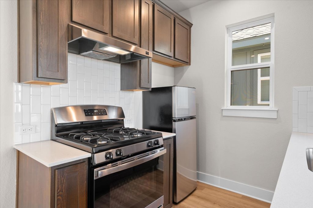 6416 Cowman Way Austin, TX 78747 - Photo 23 of 30 a kitchen with stainless steel appliances granite countertop a stove and a refrigerator