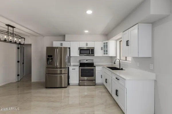 a kitchen with stainless steel appliances a refrigerator stove and microwave