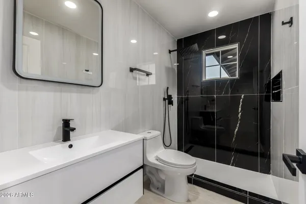 a bathroom with a sink a toilet and shower