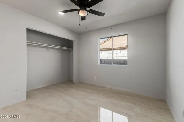 an empty room with a window and a ceiling fan
