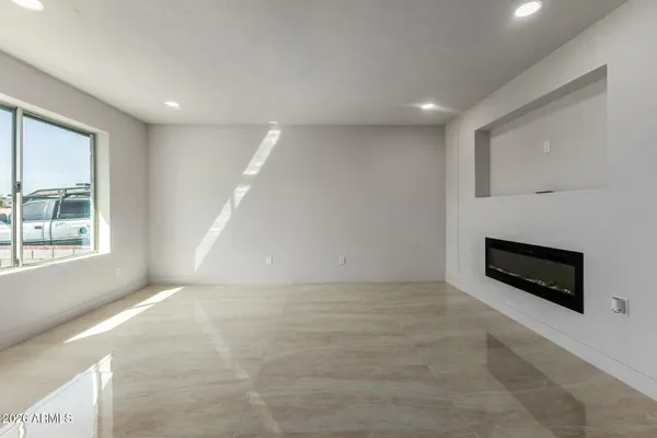 a view of an empty room with a fireplace and a window