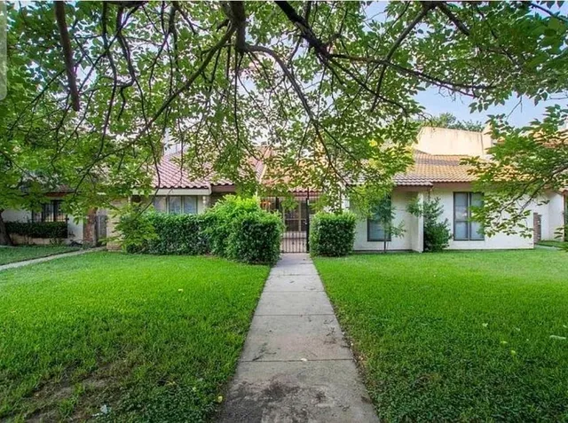 a front view of a house with a yard and trees
