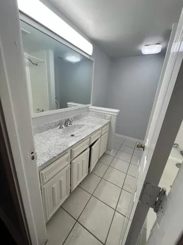 a bathroom with a granite countertop sink and a mirror