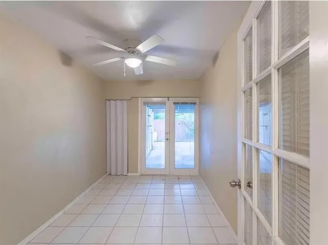 a view of a hallway with a chandelier fan and windows