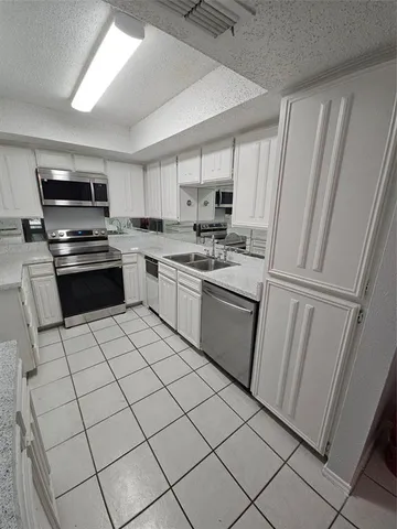 a kitchen with stainless steel appliances a refrigerator sink and microwave