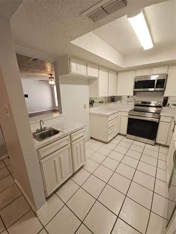 a kitchen with a stove sink and white cabinets