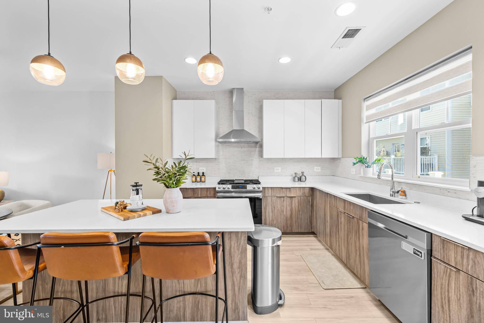4509 12th Street Northeast Washington, DC 20017 - Photo 14 of 45 a kitchen with stainless steel appliances kitchen island granite countertop a sink a stove a dining table and chairs